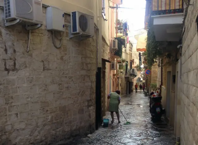 Женщина моет мостовую