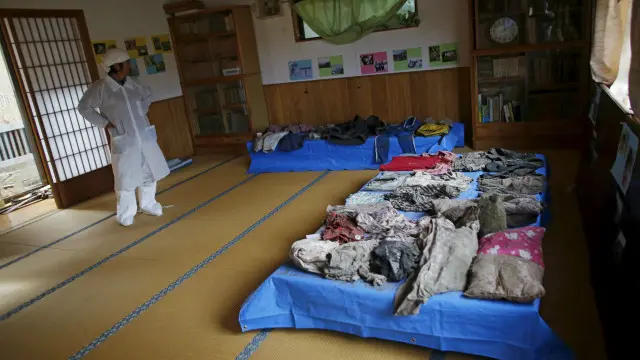 En esta imagen se observa a Norio Kimura, un hombre de 50 años que perdió a su padre, a su esposa e hijas en el tsunami de 2011. Ve las pertenencias de sus seres queridos en un templo cercano a su casa, la cual está en la zona de exclusión en Okuma. 