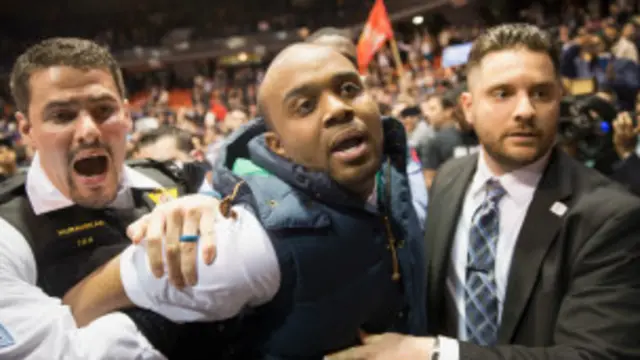 Un activista es sacado por la fuerza en Chicago durante un discurso de Trump.