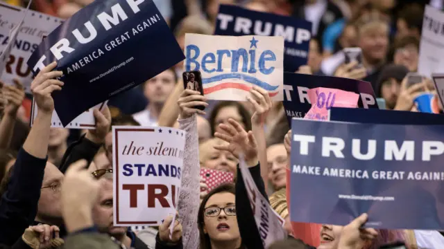 Seguidores de Trump sostienen carteles durante su presentación en Ohio.