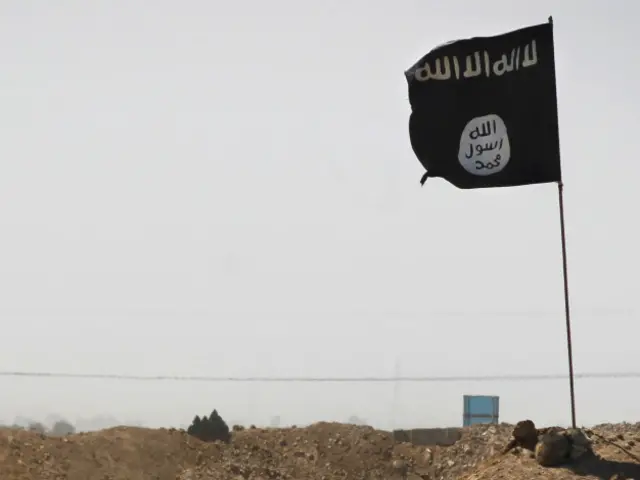 Флаг ИГ: арабская вязь с первой частью "шахады", свидетельством о вере в Единого Бога Аллаха, и печать пророка Мохаммеда снизу.