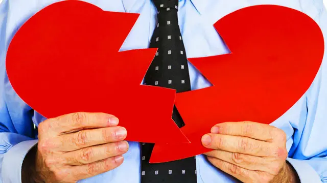 Una persona mostrando un corazón de papel roto