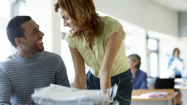 Una persona en actitud romántica hacia otra en la oficina