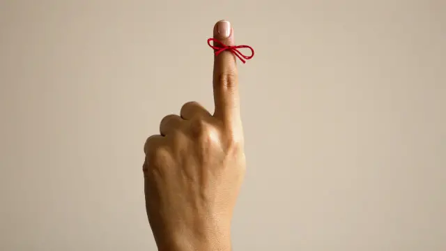 Una persona con un cordón atado en un dedo