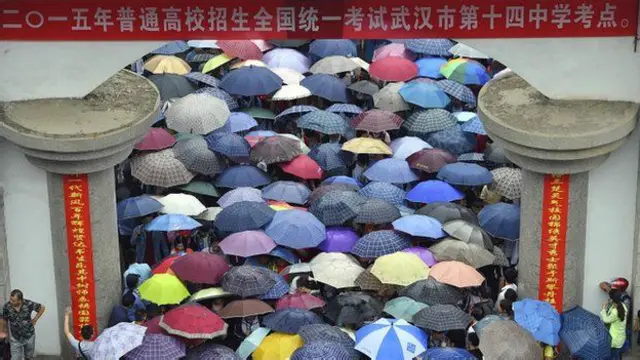 Estudiantes hacen una larga fila para hacer un examen a la entrada de una universidad en la ciudad de Wuhan