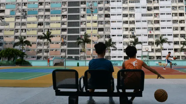 香港某處籃球場與兩名凝視球場的兒童。