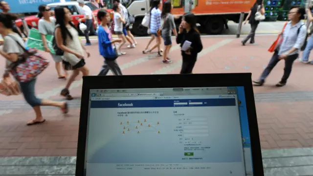 在香港街頭使用臉書(facebook)示意圖。