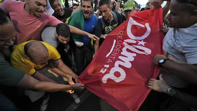 Manifestantes jalan una pancarta con la palabra "Dilma" en señal de protesta frente al palacio de gobierno en Brasilia