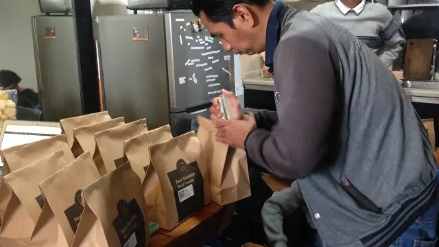 Kurir menyiapkan paket antaran katering pelanggan Kotak Sarapan.