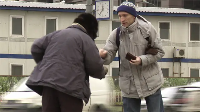Прохожий подает милостыню