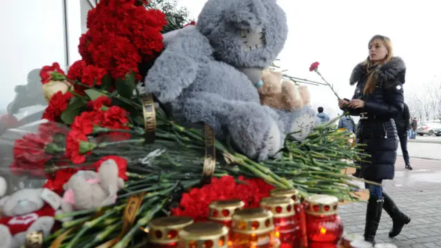 Люди приносят цветы