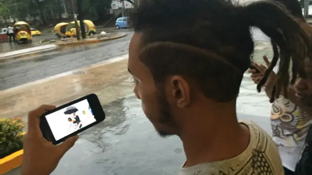 Omar mira la llegada de Obama desde su celular inteligente 