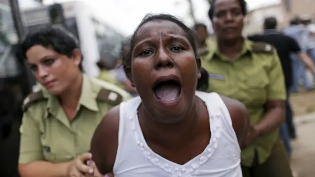 Una integrante de las "Damas de Blanco" grita mientras la policía la aparta