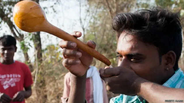 महुआ पीते आदिवासी युवक