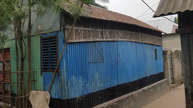 গোকর্ণ ঘাটের মালোপাড়ায় অদ্বৈত মল্লবর্মণের বসতভিটা ছিল এখানে। দুই তিন হাত ঘুরে সেই ভিটায় নীলরঙা এই ঘরটি তুলে এখন থাকছে আরেক মল্লবর্মণ পরিবার। 