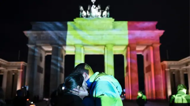 一对情侣在柏林布兰登堡门前拥抱
