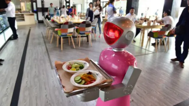 在中国，一个服务员机器人正在送餐。(图片来源：China Foto Press/Getty Images)