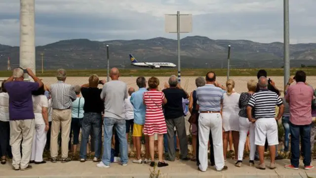 Personas viendo despegar un avión