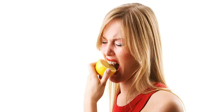 Дівчина кусає лимон