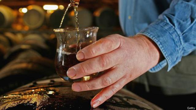 在布莱迪（Bruichladdich）酿酒厂从木桶中提取威士忌样本。