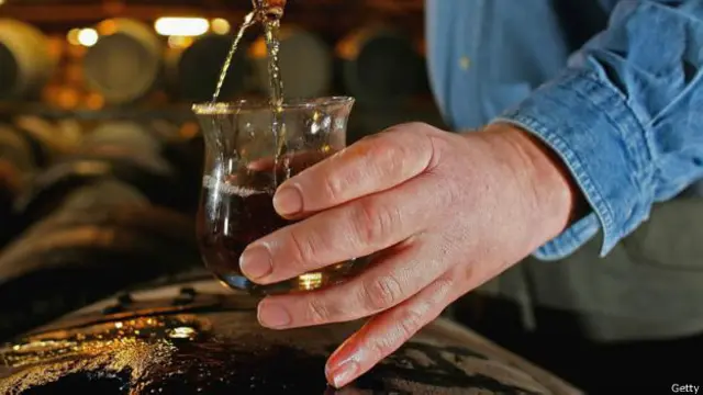 在布莱迪(Bruichladdich)酿酒厂从木桶中提取威士忌样本。