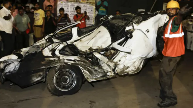 Un rescatista retira un vehículo aplastado por el derrumbe