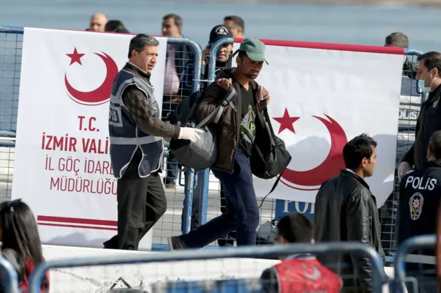 土耳其警方人员在接受抵达的移民