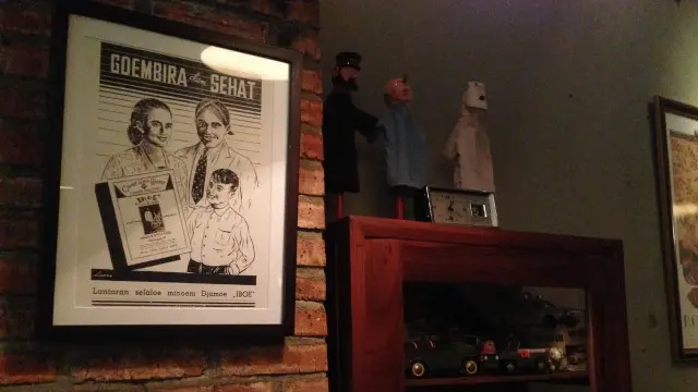 Dinding kedai Suwe Ora Jamu menampilkan poster iklan jamu kuno.