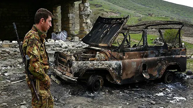 Erməni əsgər Talış kəndində yanmış maşına tamaşa edir.
