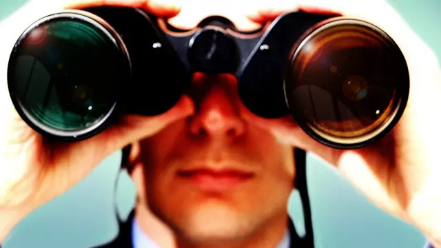 Un hombre mira con unos binoculares