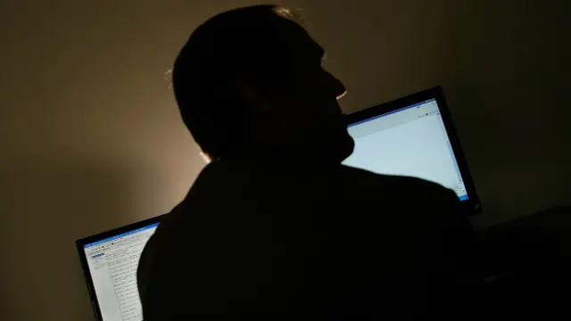 Hombre de espalda a dos pantallas