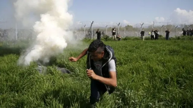 مهاجرون يفرون من الغاز المسيل للدموع عند السياج الحدودي