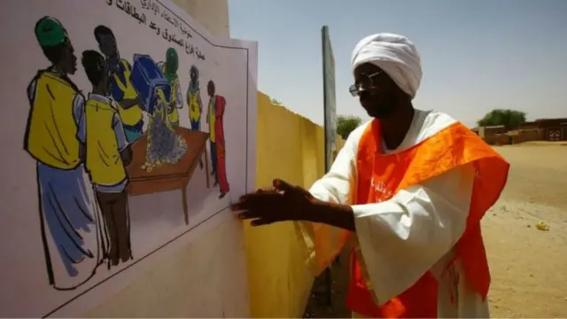 رجل يعلق لوحة بخصوص الاستفتاء