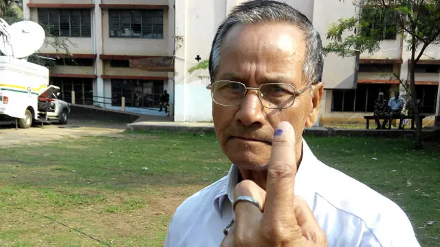 असम में मतदान के बाद स्याही लगी उंगली दिखाता एक मतदाता.