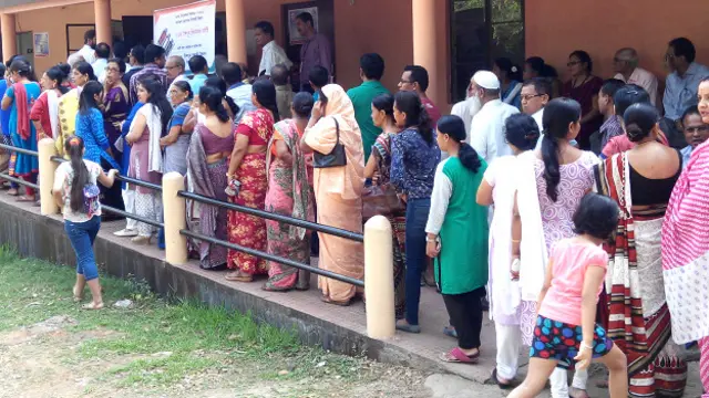 गुवाहाटी में मतदान के लिए कतार में खड़े लोग.