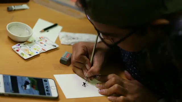 Ara menunjukan keahliannya melukis obyek mini di kantor BBC Indonesia.