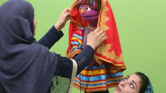 Altı yaşındaki bir kız çocuğunu temsil eden Zari, geleneksel baş örtüsü takıyor. Kıyafeti de yerel kumaş ve desenleri içerecek.