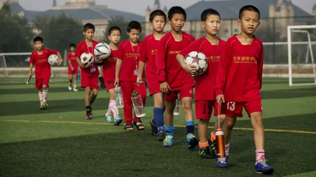 Niños chinos jugando al fútbol