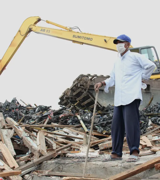 Seorang bekas penghuni kampung Pasar Ikan tengah mengawasi bekas rumahnya.