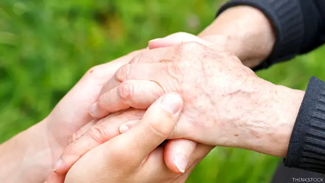 Una persona sosteniendo las manos de un familiar con la enfermedad de Parkinson