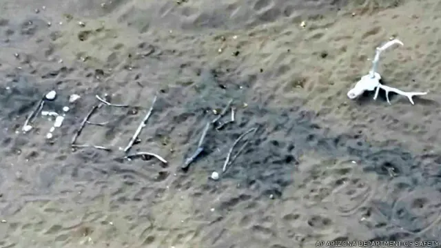 Mensaje con la palabra Help, Ayuda, que Rodgers armó con palos