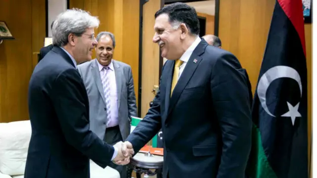 السراج (إلى اليمين) يصافح وزير الخارجية الإيطالي الذي كان يعرب عن دعمه لحكومة الوفاق