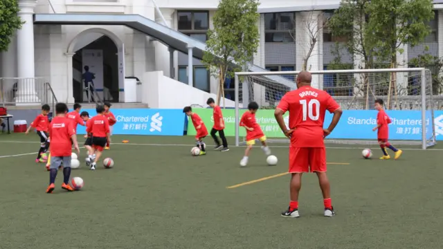巴恩斯(10号)在香港一所国际学校的足球培训营指导学员