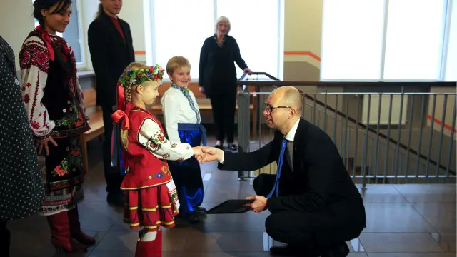 Арсеній Яценюк і маленька дівчинка в українському вбранні 