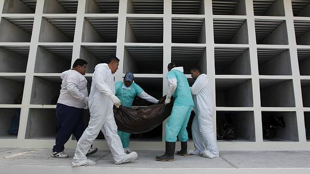 Trabajadores de una morgue cargan un cadáver
