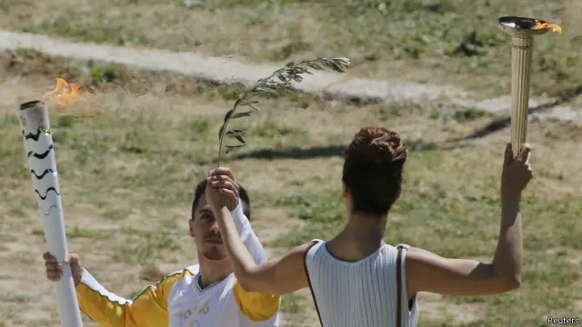 سلمت كاترينا ليو الشعلة إلى اليوناني "إلفثيريوس بترونياس" بطل العالم في رياضة الجمباز