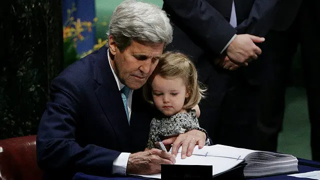 وزير الخارجية الأمريكي يحمل حفيدته أثناء توقيع الاتفاقية