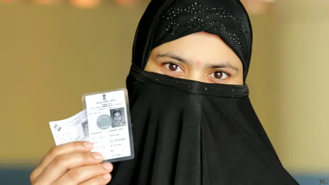 मतदाता पहचान पत्र दिखाती एक महिला.