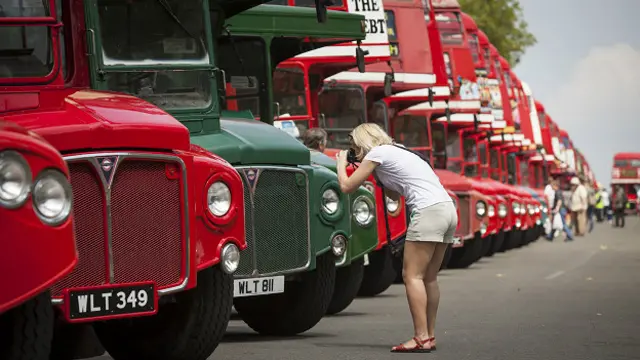 Женщина фотографирует старые автобусы