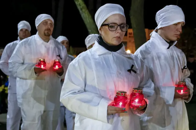 Працівники ЧАЕС у робочому одязі під час нічної церемонії у Славутичі